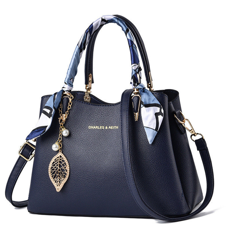 Damen-Schultertasche mit Blattanhänger und modischem Seidenschal