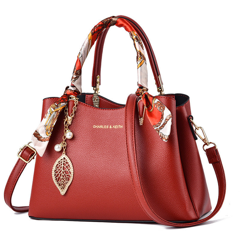Damen-Schultertasche mit Blattanhänger und modischem Seidenschal