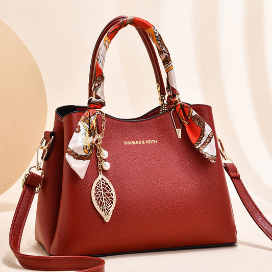 Damen-Schultertasche mit Blattanhänger und modischem Seidenschal