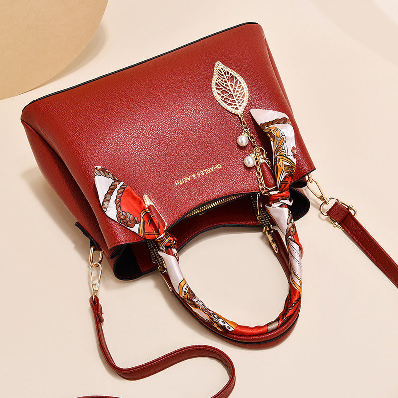 Damen-Schultertasche mit Blattanhänger und modischem Seidenschal